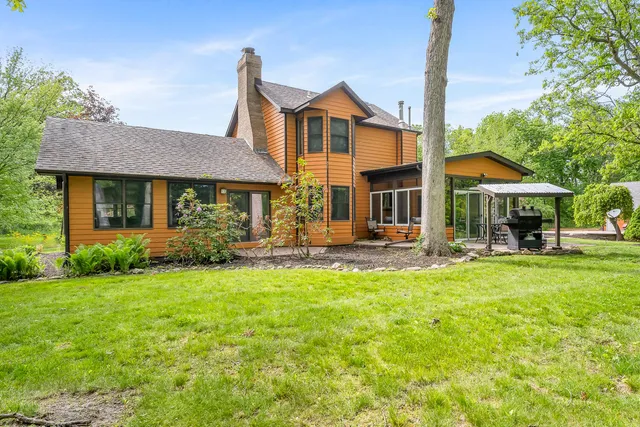 a view of a house with backyard and sitting area
