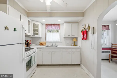 a kitchen with granite countertop a refrigerator a sink stainless steel appliances and cabinets