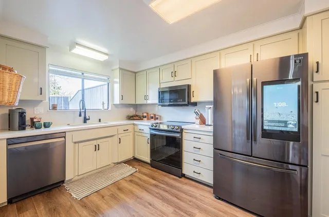 a kitchen with stainless steel appliances a refrigerator sink and microwave