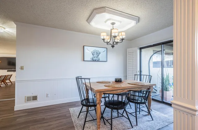 a view of a dining room with furniture a chandelier and wooden floor