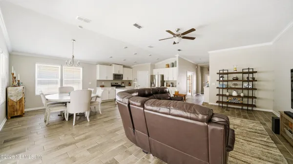 a living room with furniture a dining table and chairs with wooden floor