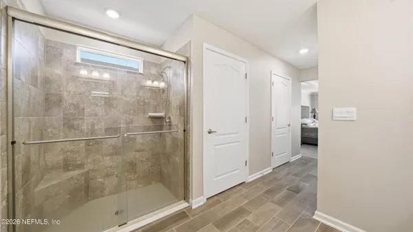a view of a hallway with wooden floor windows and a living room