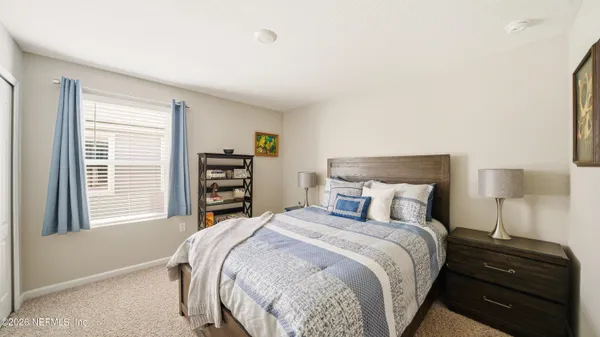 a bedroom with a bed and a painting on the wall