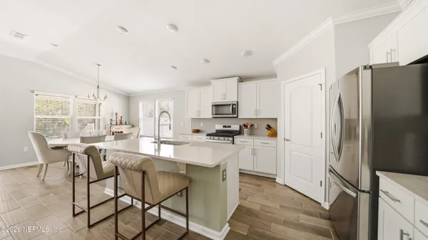a kitchen with kitchen island white cabinets and stainless steel appliances