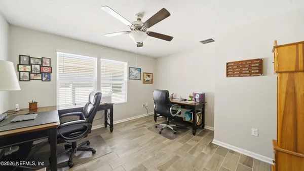 a view of a workspace with furniture and a window