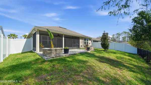 a view of a house with backyard and a tree