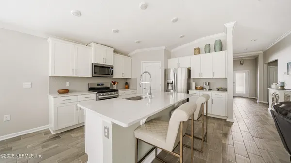 a kitchen with white cabinets and stainless steel appliances