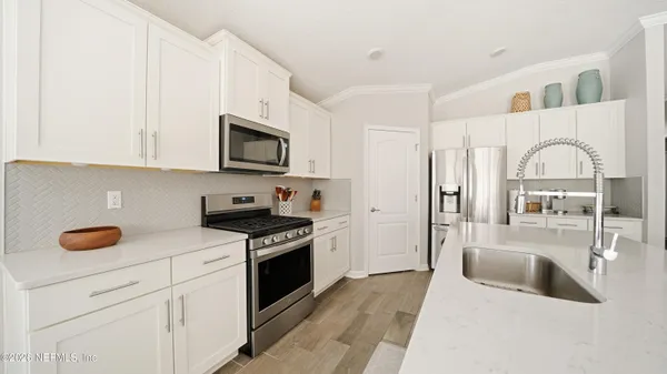 a kitchen with stainless steel appliances granite countertop a stove a sink and a microwave