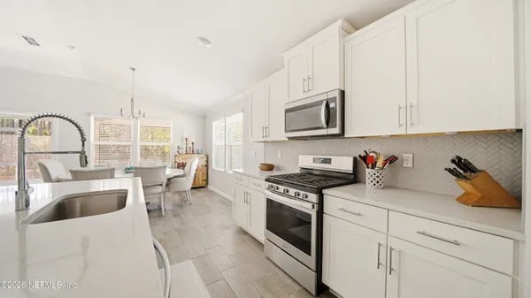 a kitchen with granite countertop a sink a stove and cabinets