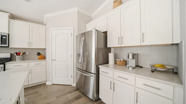 a kitchen with stainless steel appliances white cabinets and a refrigerator