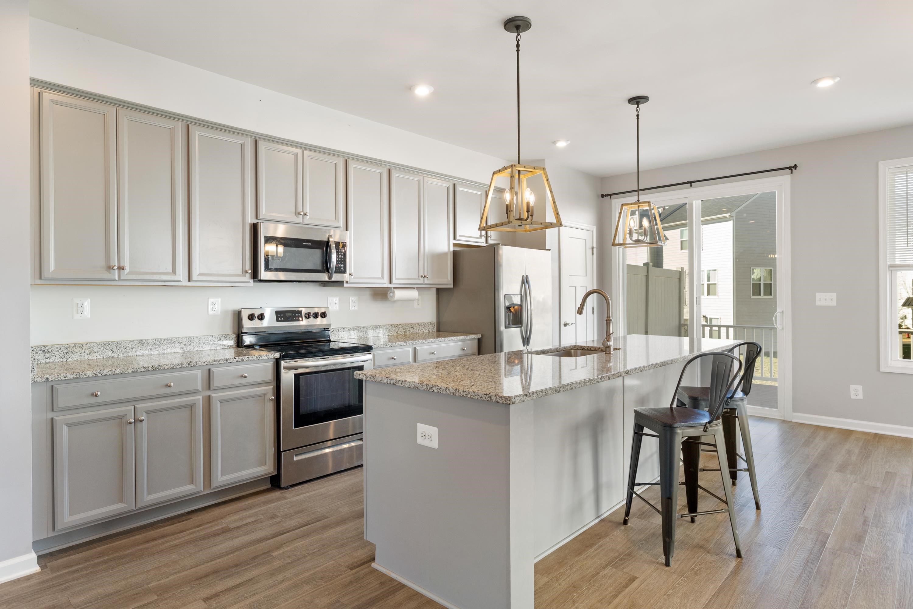4416 Alston Street Crozet, VA 22932 - Photo 9 of 36 a kitchen with kitchen island granite countertop a sink a stove a refrigerator and island with wooden floor