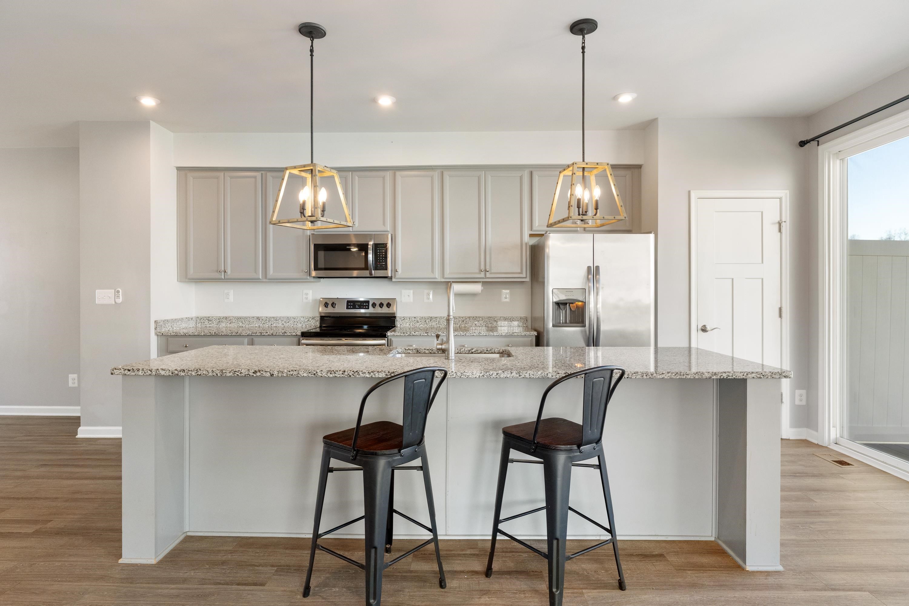 4416 Alston Street Crozet, VA 22932 - Photo 10 of 36 a kitchen with stainless steel appliances granite countertop a stove top oven a refrigerator a sink and chairs