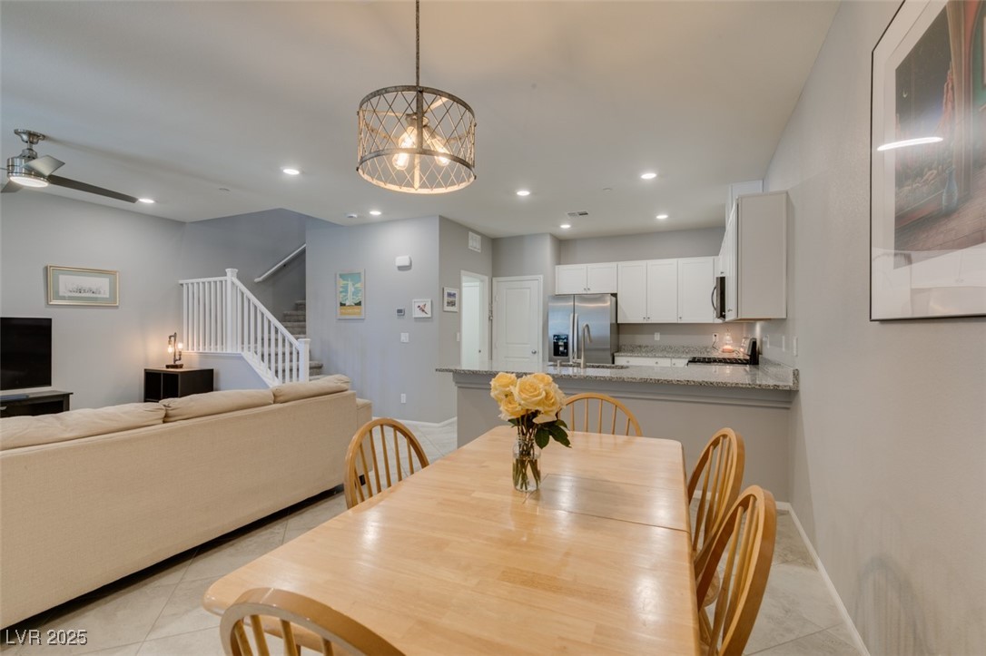 2870 Turnstone Ridge Street Henderson, NV 89044 - Photo 18 of 50 Dining room with stairway, light tile patterned floors, recessed lighting, baseboards, and a chandelier
