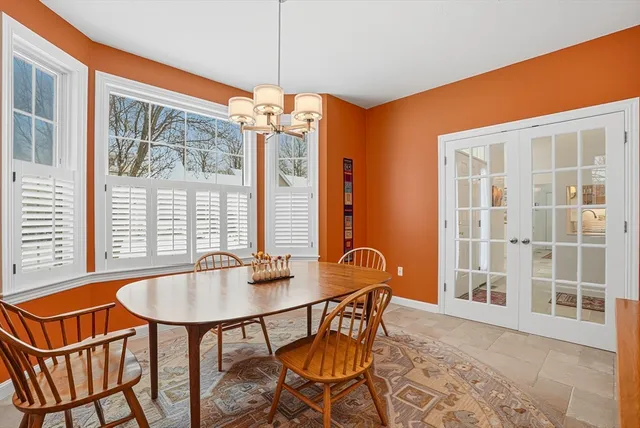 a dining room with furniture a chandelier and wooden floor