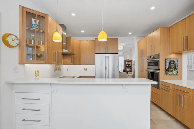 a view of a kitchen island a sink a refrigerator and a window