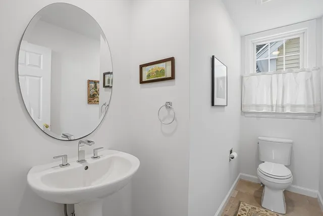 a bedroom with a bed and a lamp on dresser