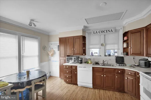 a kitchen with stainless steel appliances a stove a refrigerator a sink a stove and wooden floors