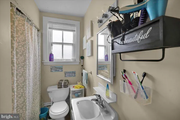 a bathroom with a sink toilet and mirror