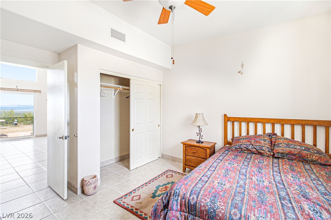 Rocking S Ranch Road Searchlight, NV 89046 - Photo 27 of 47 A comfortable bedroom with tiled floors, offering direct access to an outdoor space with picturesque views.
