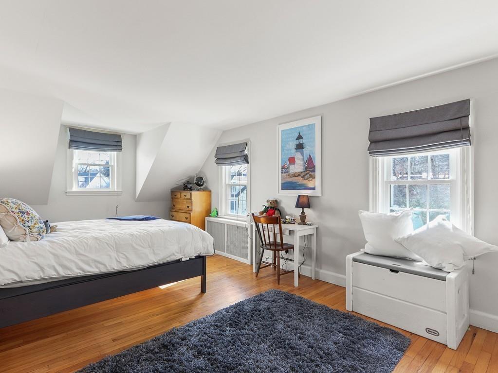 31 Emerson Place Needham, MA 02492 - Photo 20 of 27 a bedroom with a bed and wooden floor