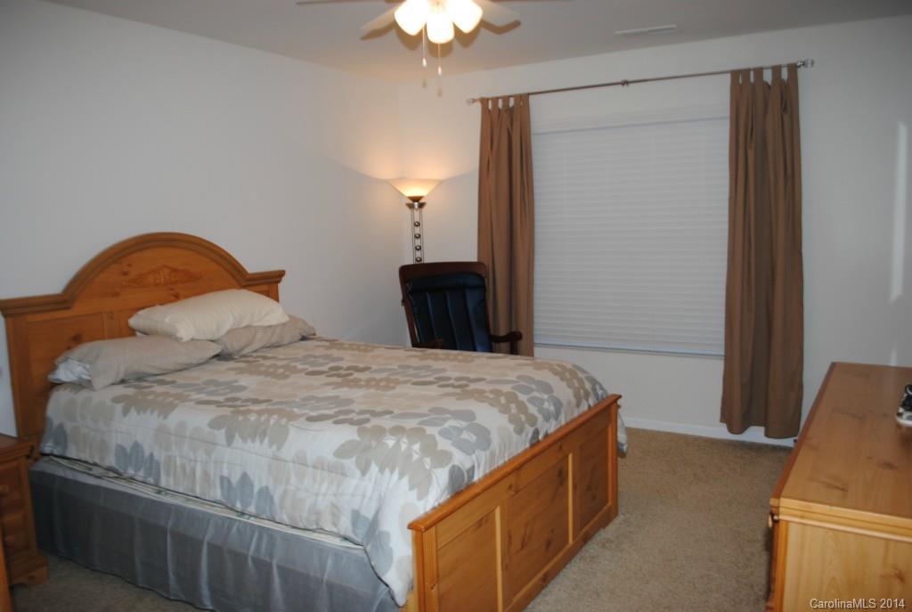 2604 Aldergrove Road Matthews, NC 28105 - Photo 12 of 16 a bedroom with a bed and a chandelier