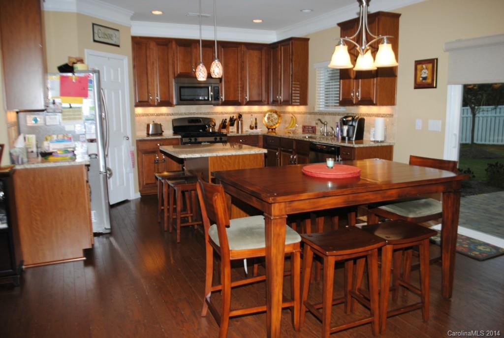 2604 Aldergrove Road Matthews, NC 28105 - Photo 6 of 16 a kitchen with a dining table chairs and a refrigerator
