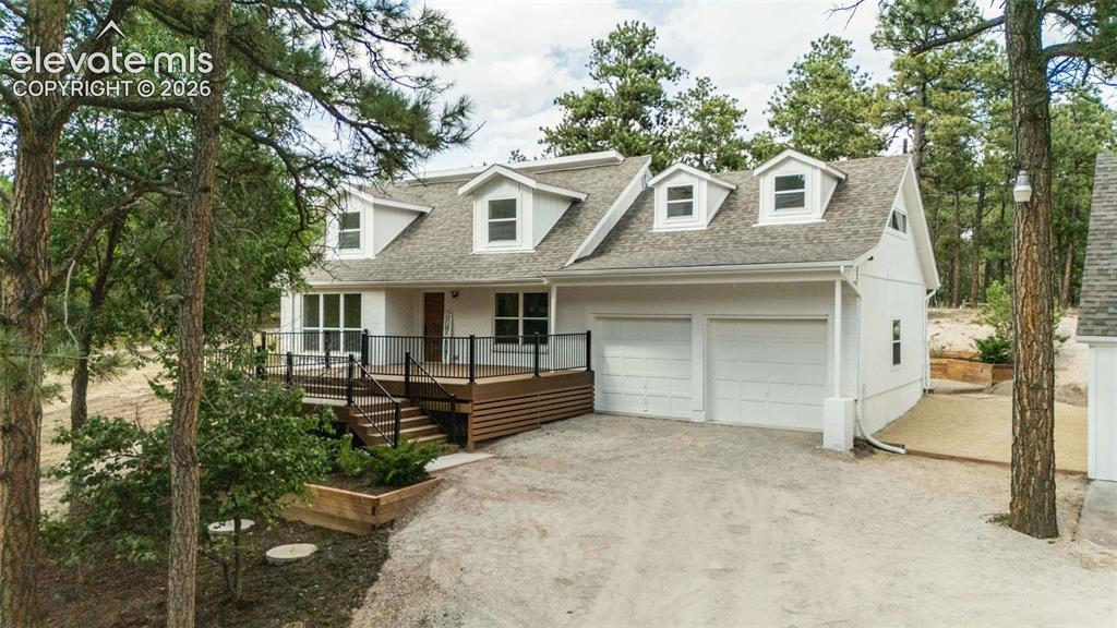 11665 Greentree Road Colorado Springs, CO 80908 - Photo 1 of 43 Cape cod-style house featuring an attached garage, driveway, a shingled roof, stairs, and a deck