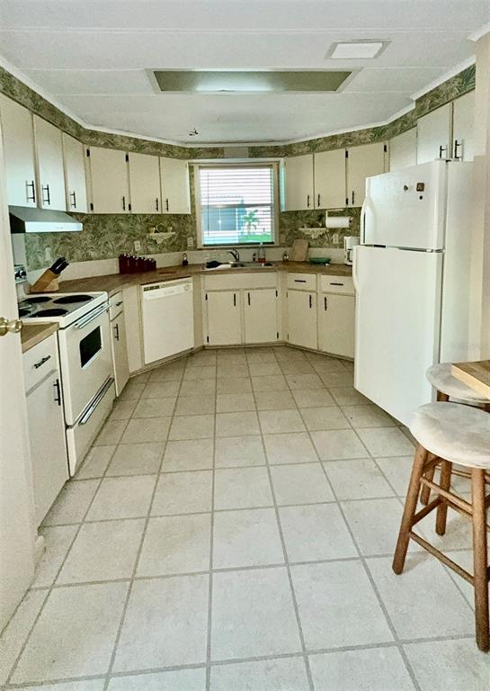 4207 13th Street East Ellenton, FL 34222 - Photo 9 of 15 a kitchen with granite countertop a stove a sink and a refrigerator