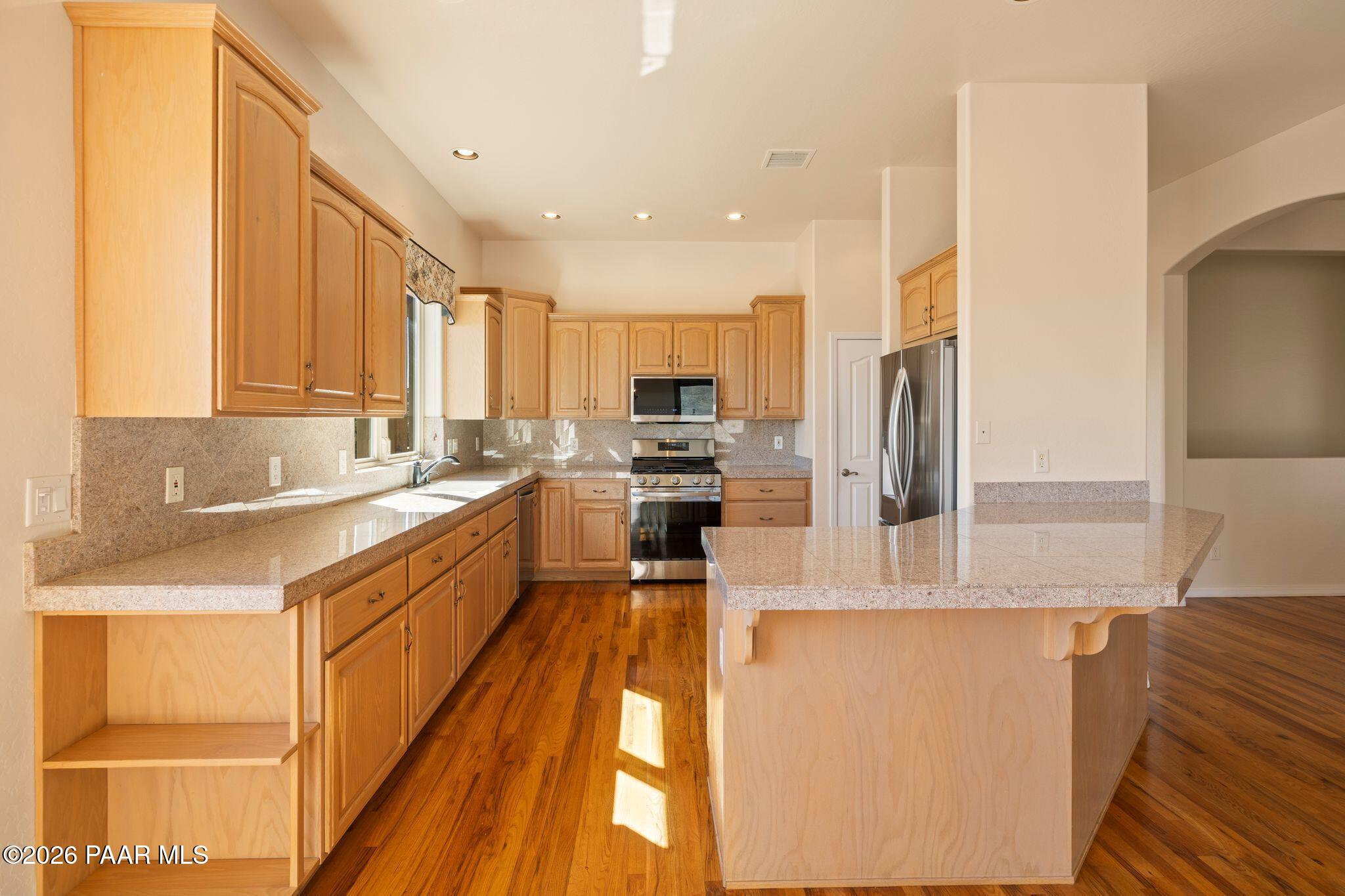 4677 Sharp Shooter Way Prescott, AZ 86301 - Photo 13 of 64 a kitchen with stainless steel appliances granite countertop a refrigerator a sink and a stove