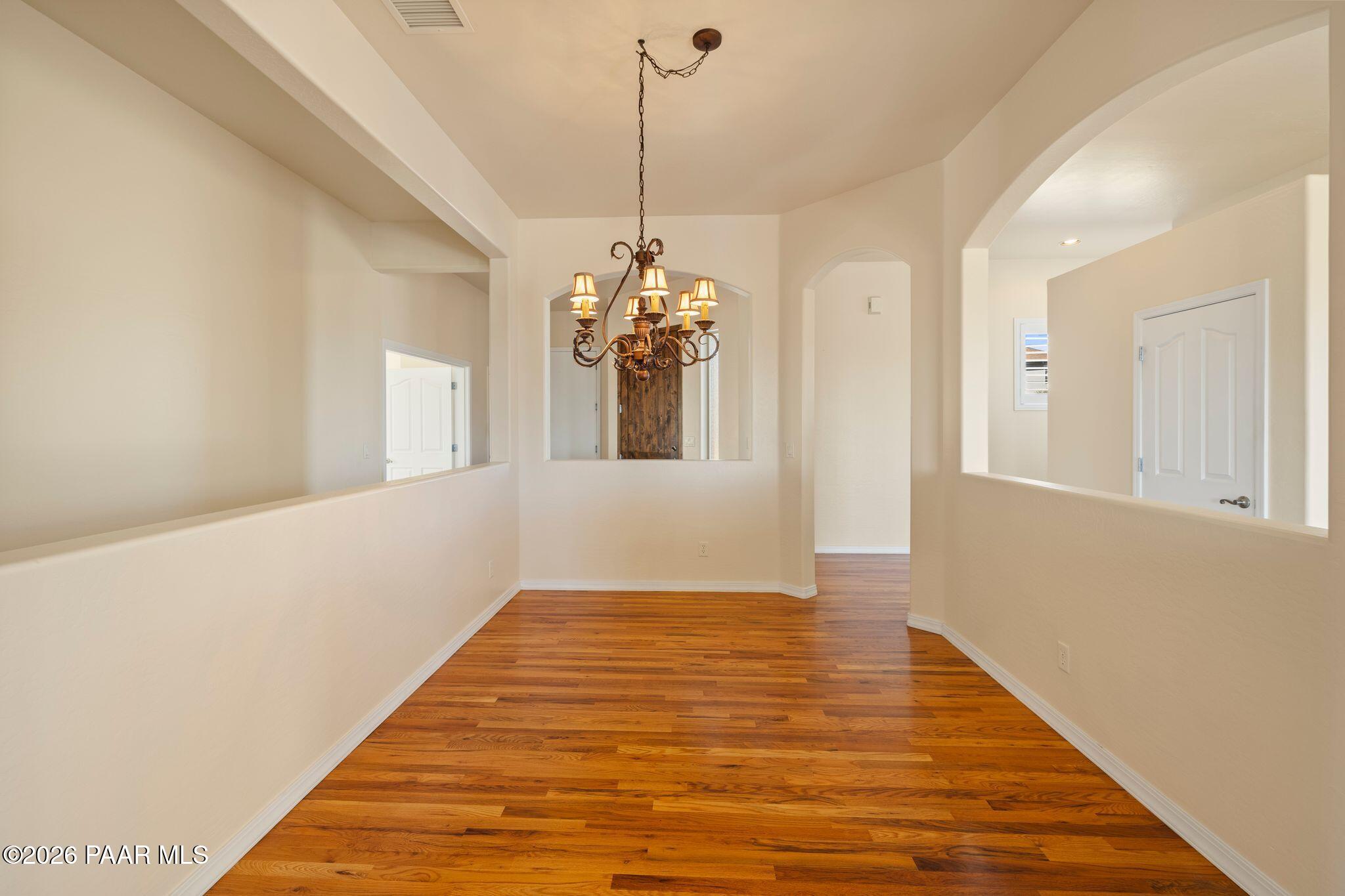 4677 Sharp Shooter Way Prescott, AZ 86301 - Photo 16 of 64 a view of a room with wooden floor and chandelier