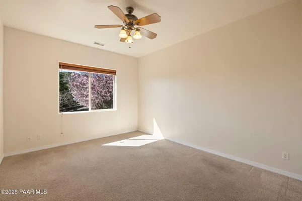 an empty room with a window and a fan