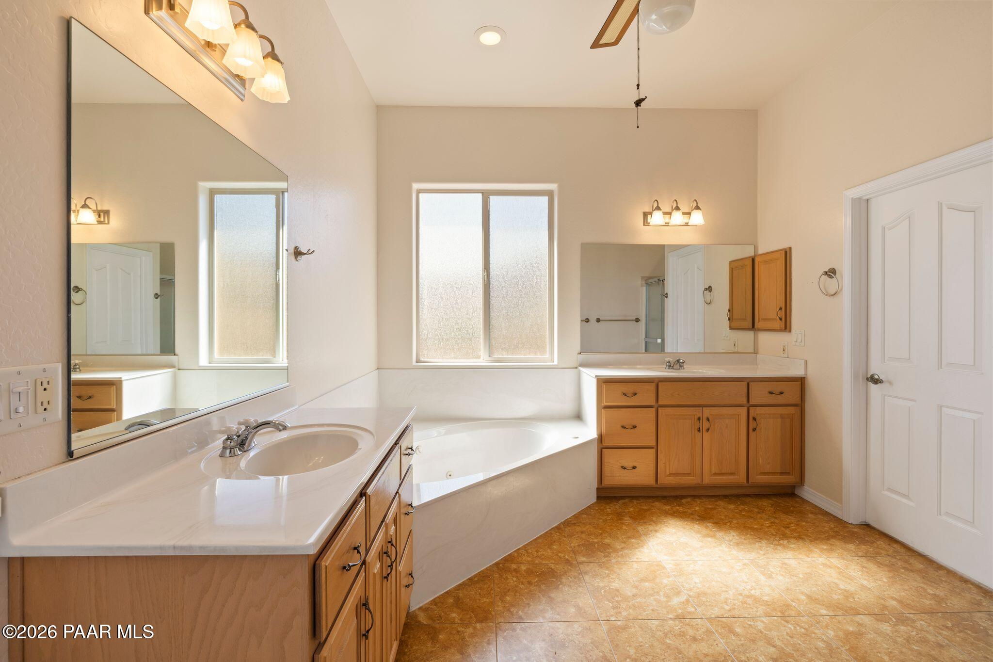4677 Sharp Shooter Way Prescott, AZ 86301 - Photo 34 of 64 a spacious bathroom with a granite countertop tub sink and mirror