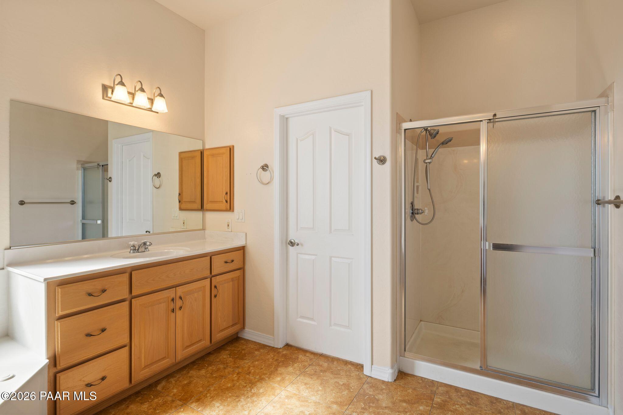 4677 Sharp Shooter Way Prescott, AZ 86301 - Photo 36 of 64 a spacious bathroom with a shower sink and mirror