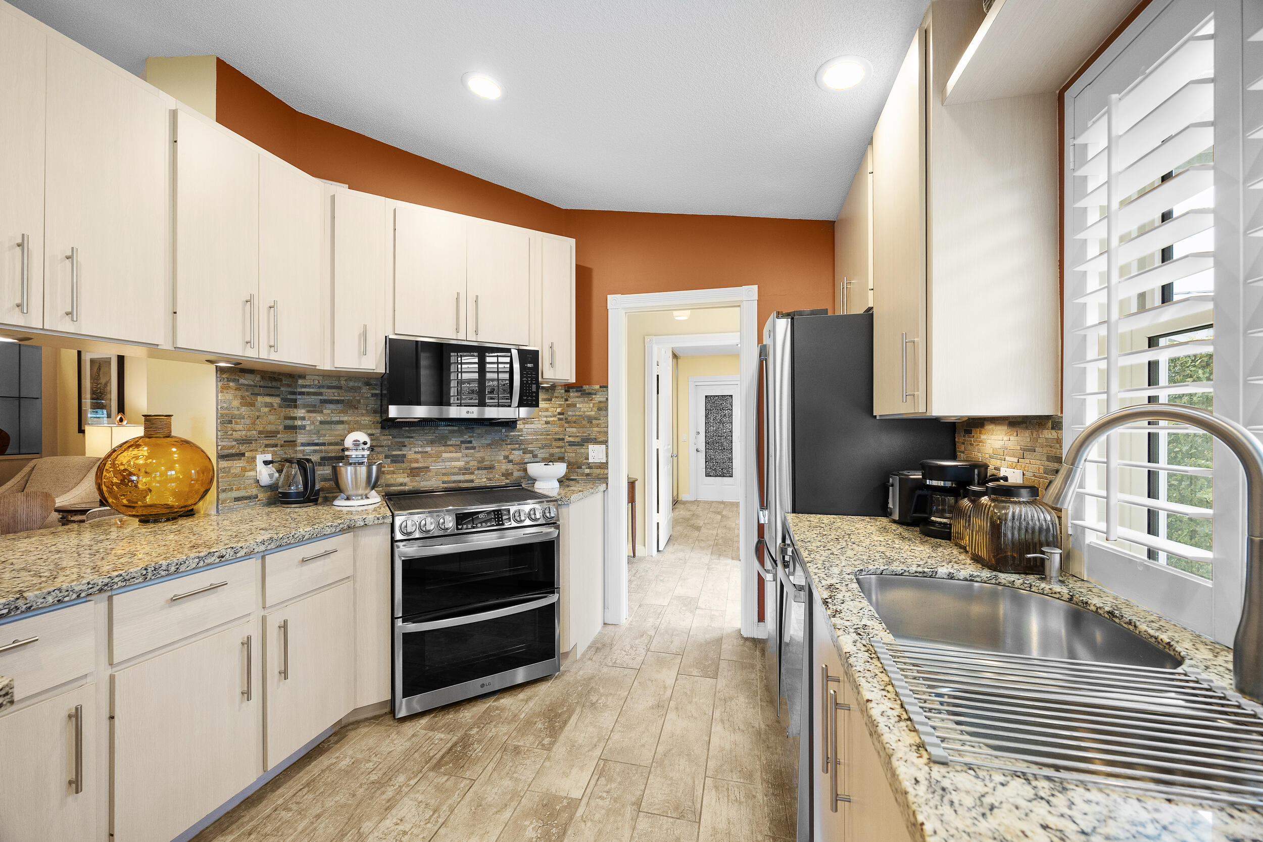 1568 Southwest Springfield Court Palm City, FL 34990 - Photo 13 of 31 a kitchen with stainless steel appliances granite countertop a stove sink and cabinets