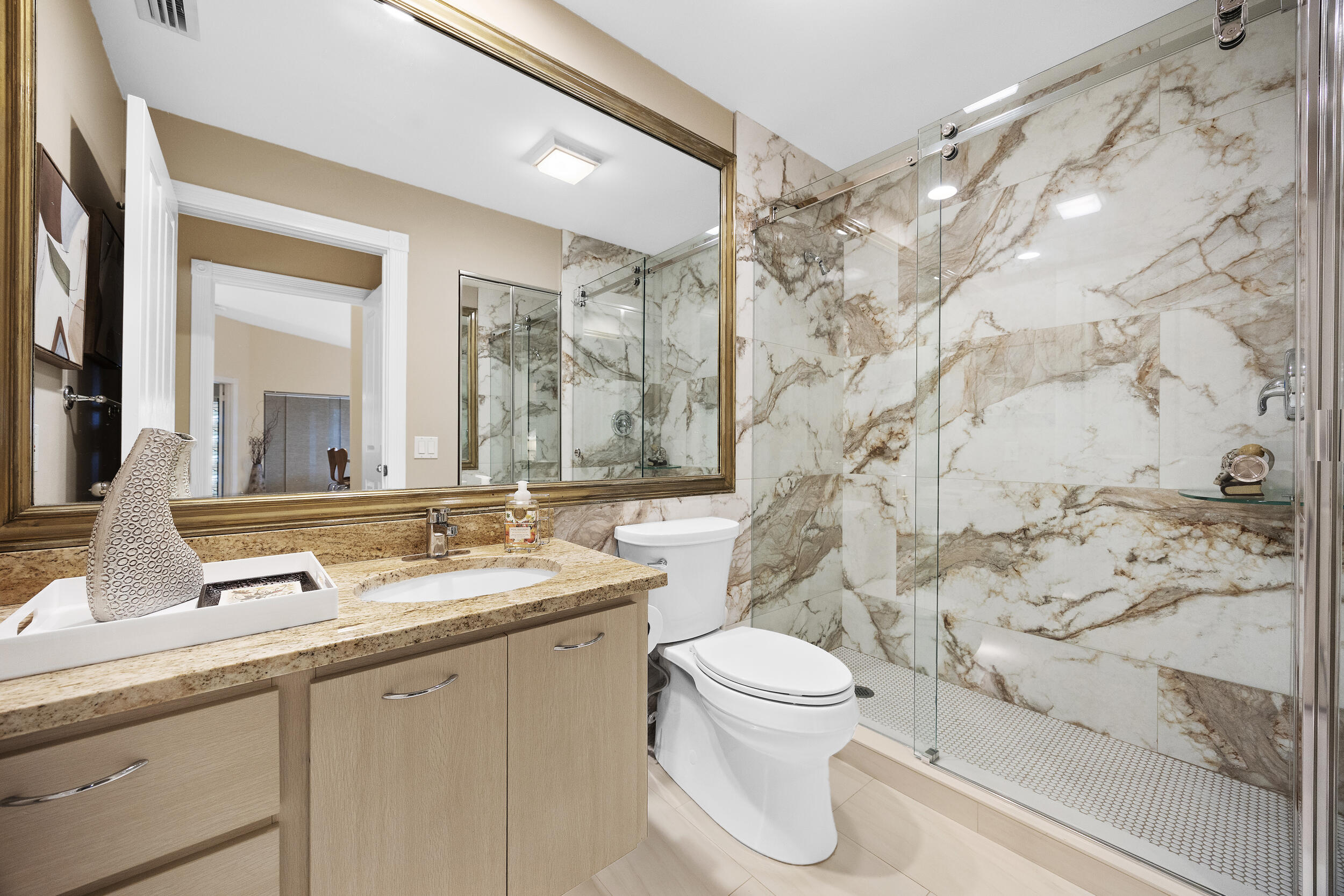1568 Southwest Springfield Court Palm City, FL 34990 - Photo 20 of 31 a bathroom with a granite countertop sink mirror vanity and toilet