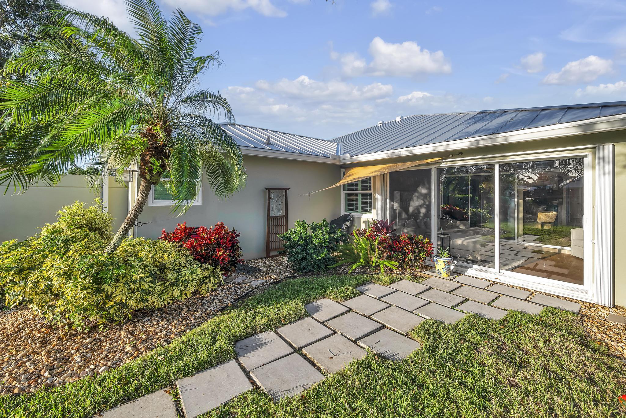 1568 Southwest Springfield Court Palm City, FL 34990 - Photo 29 of 31 a front view of a house with a big yard and a large tree