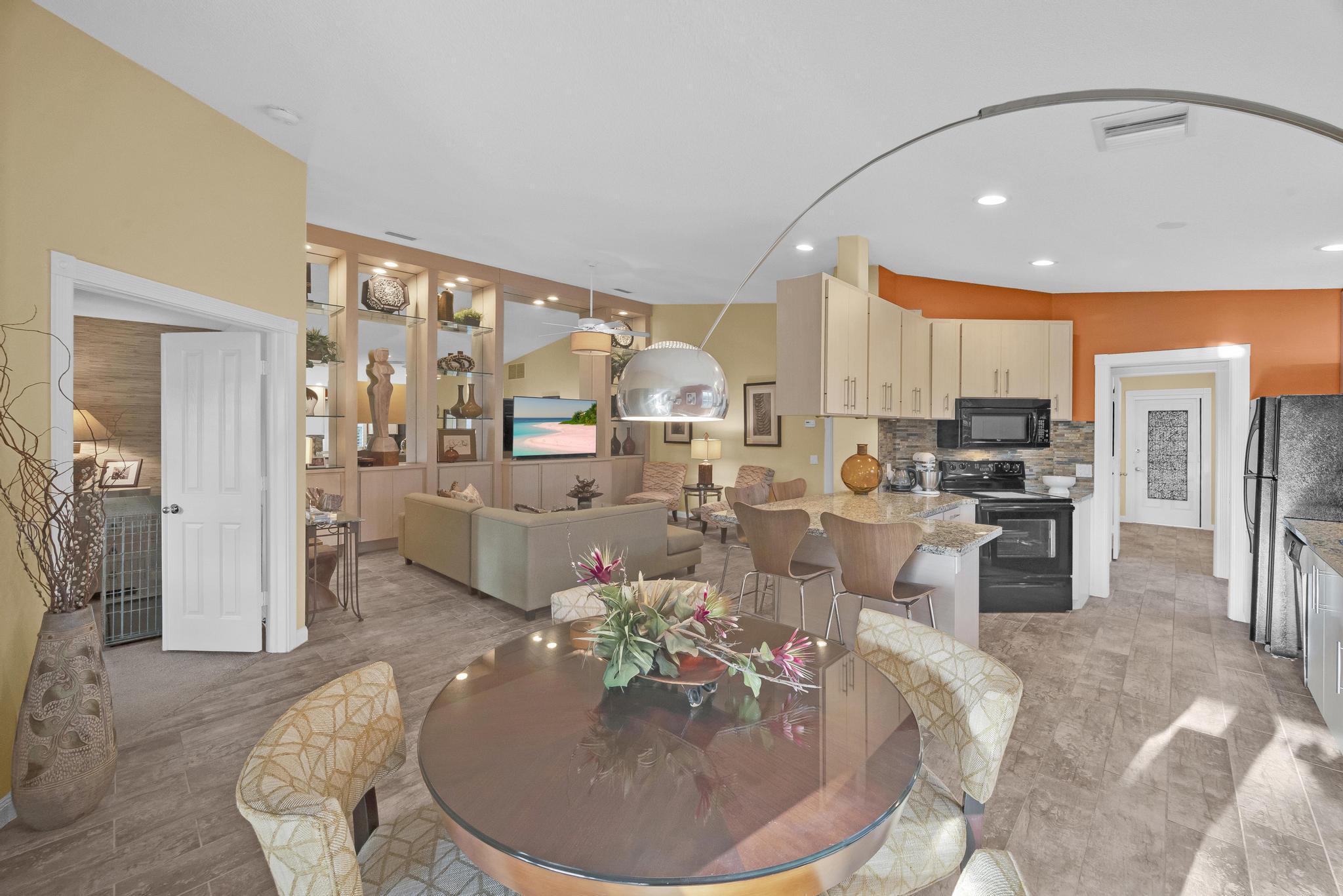 1568 Southwest Springfield Court Palm City, FL 34990 - Photo 6 of 31 a living room with large couches and kitchen view with wooden floor