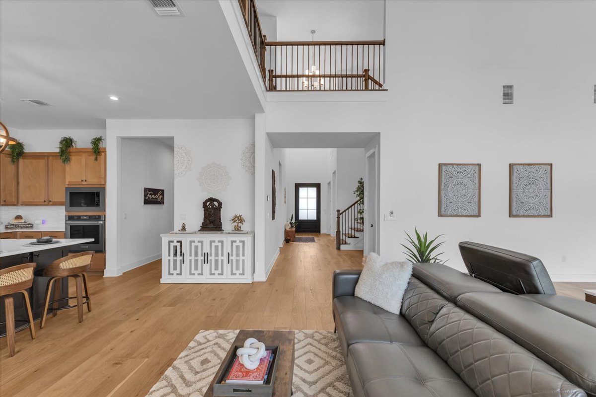 2312 Mondello Path Leander, TX 78641 - Photo 23 of 40 Living room with light wood finished floors, a high ceiling, and recessed lighting
