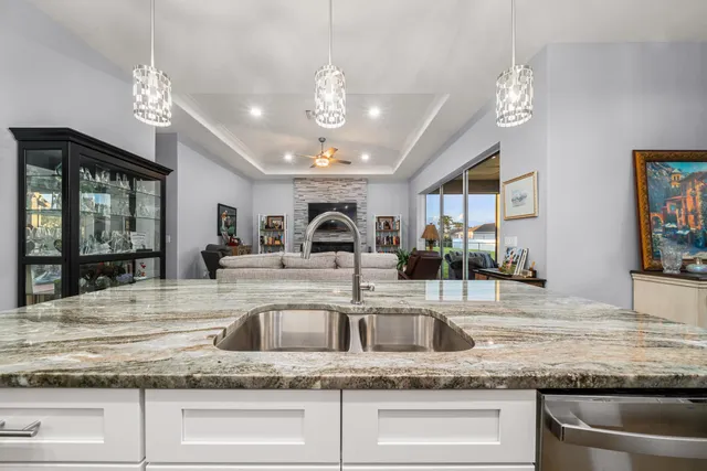 a kitchen with kitchen island granite countertop a sink and chandelier