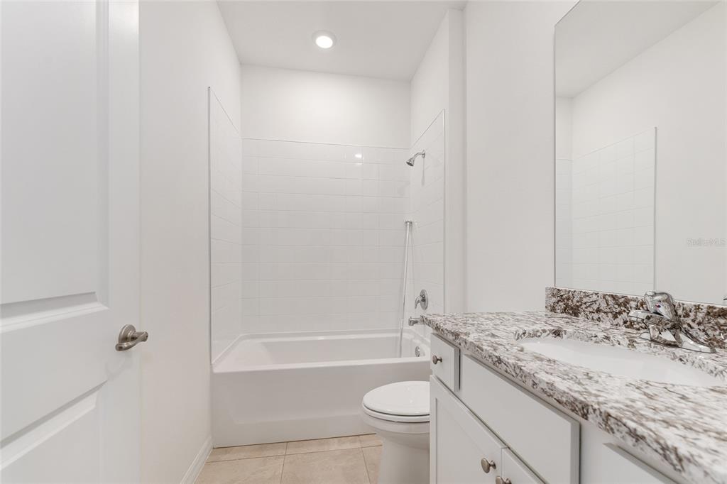 4062 Northwest 48th Terrace Ocala, FL 34482 - Photo 44 of 81 a bathroom with a granite countertop sink a toilet and bathtub