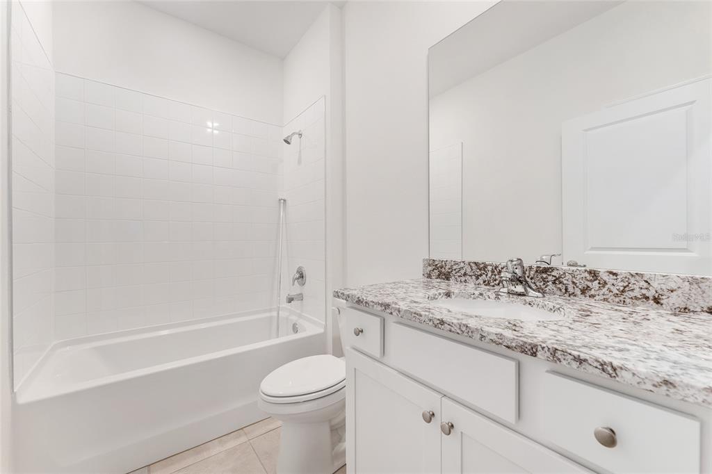 4062 Northwest 48th Terrace Ocala, FL 34482 - Photo 45 of 81 a bathroom with a granite countertop sink a toilet and bathtub