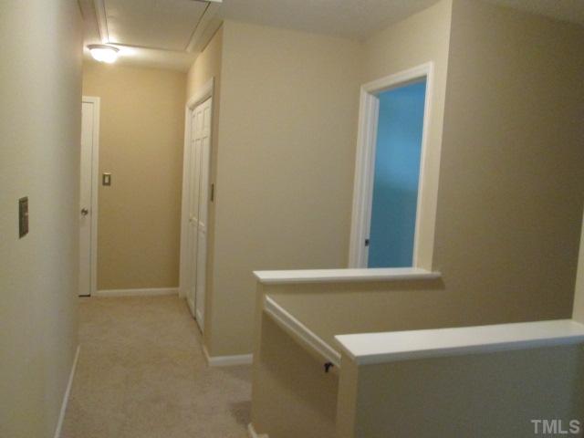 7205 St Ledger Drive Raleigh, NC 27613 - Photo 23 of 25 Hallway upstairs showing pull down attic door to the left is the walk in storage, door to the right is the front bedroom and double doors are the utility room doors! NEW carpet! NEW paint! NEW lights!