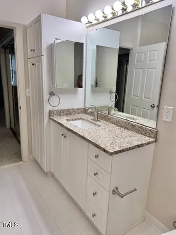 a bathroom with a granite countertop sink and a mirror