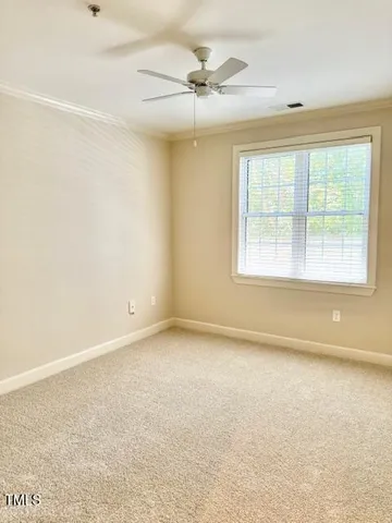 an empty room with a ceiling fan and window