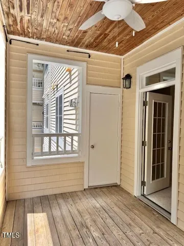 a view of a porch with wooden floor and a window