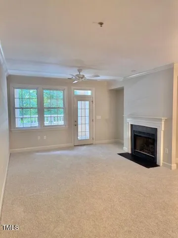 an empty room with windows and fireplace