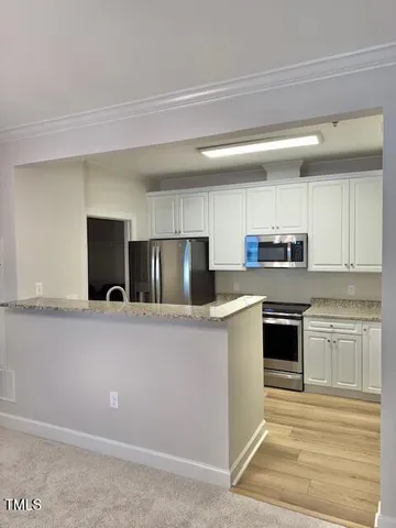 a kitchen with stainless steel appliances granite countertop a stove a sink and a refrigerator