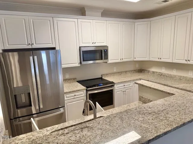 a kitchen with granite countertop a refrigerator stove and microwave