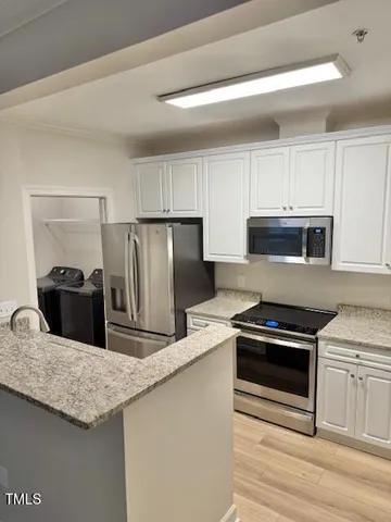 a kitchen with granite countertop a stove microwave and refrigerator