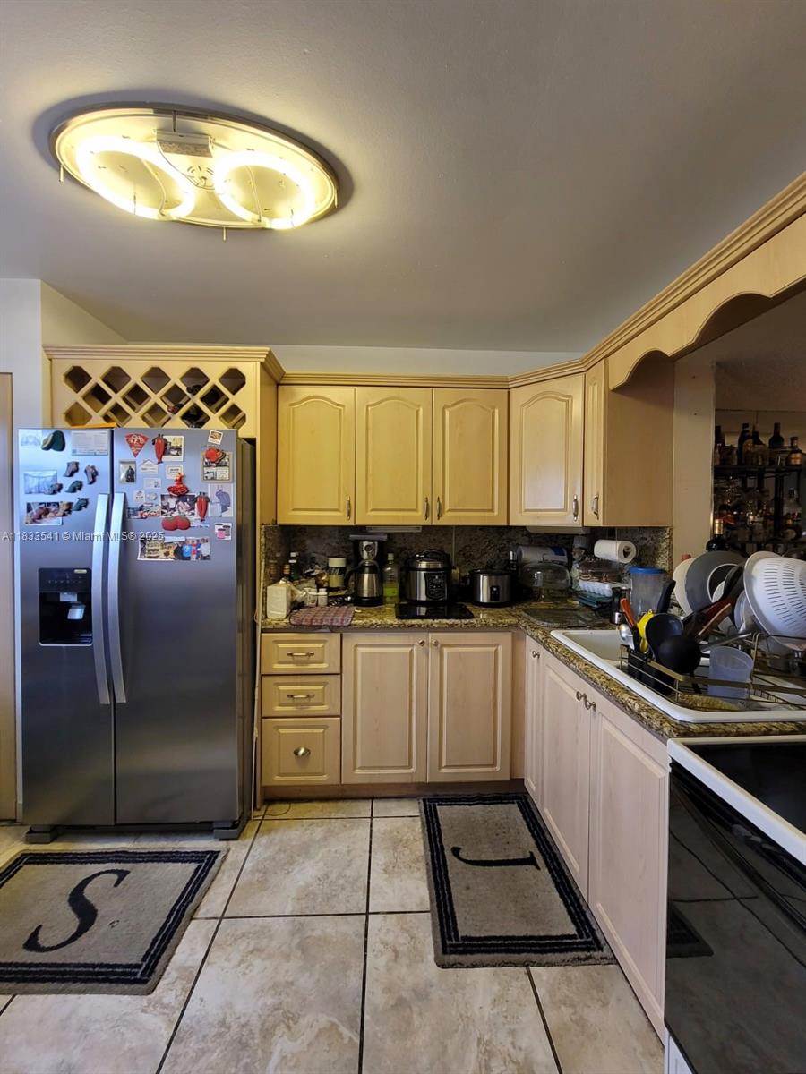 11 Olive Drive, Unit J Hialeah, FL 33010 - Photo 5 of 20 a kitchen with stainless steel appliances granite countertop a refrigerator and a stove top oven